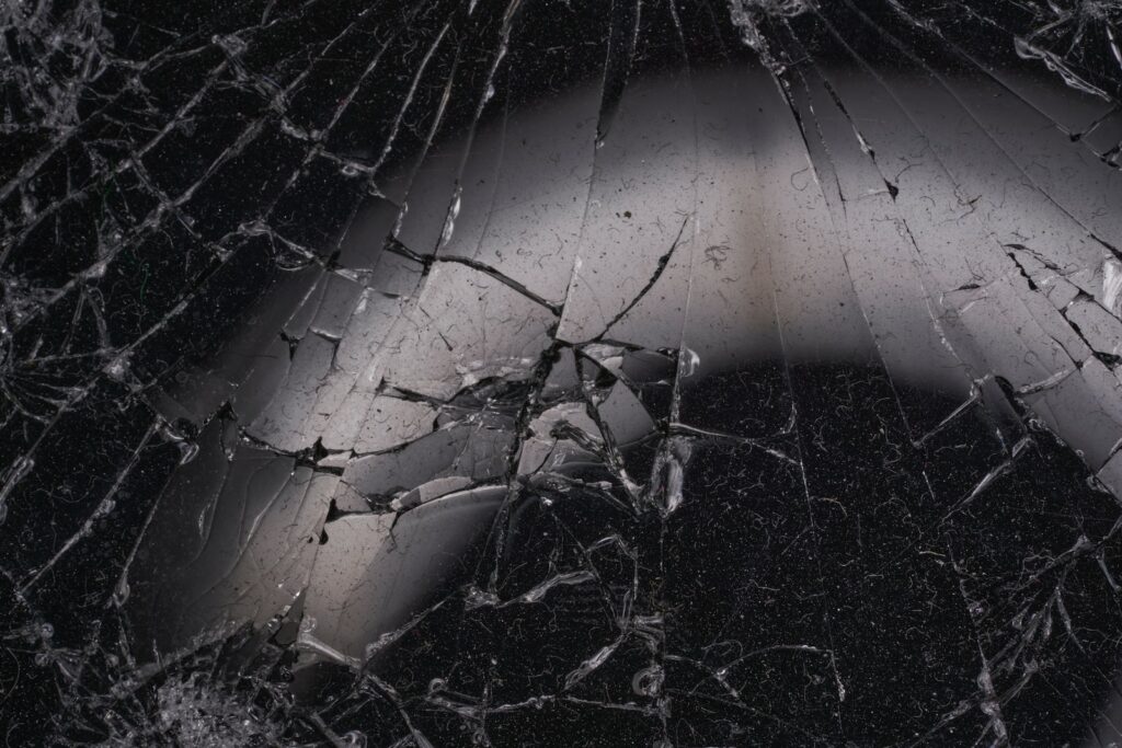 a black and white photo of a cracked window